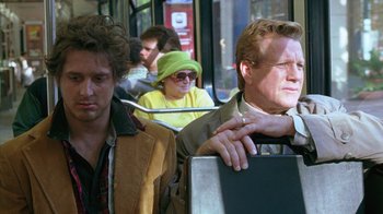Movie still from “Zero Effect” (1998), directed by Jake Kasdan – A man and a woman on a public transit bus; Medium shot, Over the shoulder angle