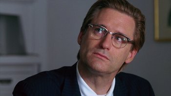 Movie still from “Zero Effect” (1998), directed by Jake Kasdan – A person wearing a suit and glasses; Close Up shot, Low angle