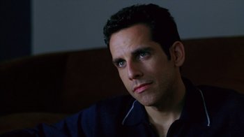 Movie still from “Zero Effect” (1998), directed by Jake Kasdan – A person sitting down looking at the camera; Close Up shot, High angle