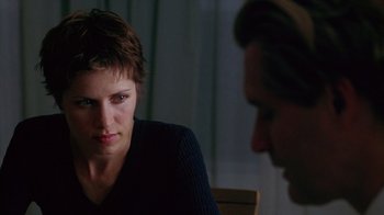 Movie still from “Zero Effect” (1998), directed by Jake Kasdan – A woman sitting in front of a man in front of a window; Close Up shot, Over the shoulder angle