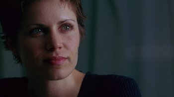 Movie still from “Zero Effect” (1998), directed by Jake Kasdan – A woman's face in a dark room; Close Up shot, Over the shoulder angle