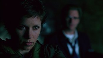 Movie still from “Zero Effect” (1998), directed by Jake Kasdan – A woman and a man in a dark room; Close Up shot, Over the shoulder angle