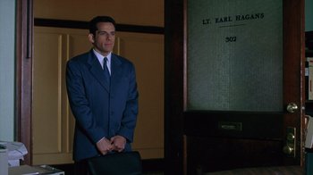 Movie still from “Zero Effect” (1998), directed by Jake Kasdan – A man in a suit and tie holding a briefcase; Medium shot, Low angle