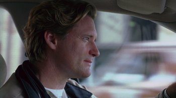 Movie still from “Zero Effect” (1998), directed by Jake Kasdan – A person sitting in a car; Close Up shot, Low angle