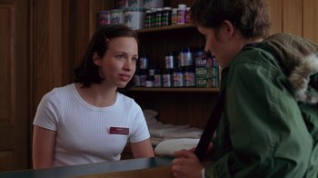 Movie still from “Zero Effect” (1998), directed by Jake Kasdan – A woman sitting at a counter talking to a man; Medium shot, Over the shoulder angle