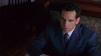 Movie still from “Zero Effect” (1998), directed by Jake Kasdan – A man wearing a suit and tie sitting at a table; Close Up shot, High angle