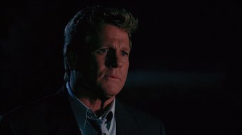 Movie still from “Zero Effect” (1998), directed by Jake Kasdan – A person wearing a suit and tie; Close Up shot, Low angle