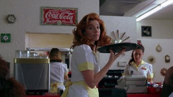 Movie still from “Zero Effect” (1998), directed by Jake Kasdan – A woman holding a tray in a restaurant; Medium shot, Low angle