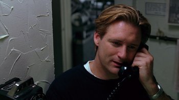 Movie still from “Zero Effect” (1998), directed by Jake Kasdan – A man talking on a phone while wearing a black shirt; Close Up shot, Low angle