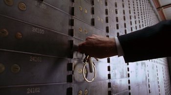 Movie still from “Zero Effect” (1998), directed by Jake Kasdan – A hand is holding a pair of scissors in front of a door; Extreme Close Up shot, Low angle
