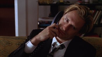Movie still from “Zero Effect” (1998), directed by Jake Kasdan – A man wearing a suit and tie talking on a phone; Close Up shot, Low angle