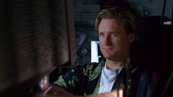 Movie still from “Zero Effect” (1998), directed by Jake Kasdan – A person sitting at a table; Close Up shot, Low angle