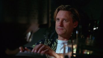 Movie still from “Zero Effect” (1998), directed by Jake Kasdan – A person sitting at a table using a computer; Close Up shot, Low angle