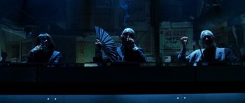 Movie still from “Zoolander” (2001), directed by Ben Stiller – A man holding an open fan while smoking a cigarette; Medium shot, Low angle