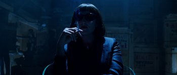 Movie still from “Zoolander” (2001), directed by Ben Stiller – A woman smoking a cigarette while wearing sunglasses; Medium shot, Low angle