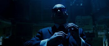 Movie still from “Zoolander” (2001), directed by Ben Stiller – A man in a suit and sunglasses putting on a tie; Close Up shot, Low angle