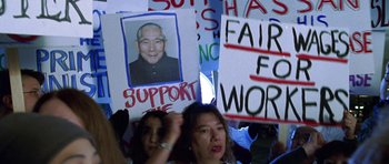 Movie still from “Zoolander” (2001), directed by Ben Stiller – A group of people holding up signs with a picture on them; Close Up shot, High angle