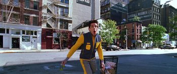 Movie still from “Zoolander” (2001), directed by Ben Stiller – A man in a yellow and gray jacket holding an umbrella; Wide shot, Low angle