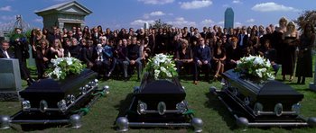 Movie still from “Zoolander” (2001), directed by Ben Stiller – A group of people gathered around a casket in a field; Wide shot, High angle