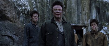 Movie still from “Zoolander” (2001), directed by Ben Stiller – Two men standing next to each other in front of a rock wall; Medium shot, Low angle