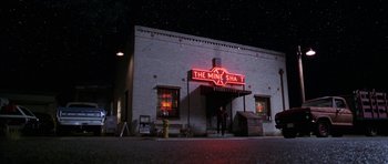 Movie still from “Zoolander” (2001), directed by Ben Stiller – A man standing in front of a building at night; Extreme Wide shot, Low angle