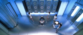 Movie still from “Zoolander” (2001), directed by Ben Stiller – A group of people standing in a room; Wide shot, Overhead angle