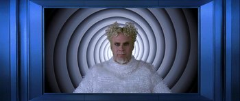 Movie still from “Zoolander” (2001), directed by Ben Stiller – A woman in a white dress and a blue background; Medium shot, Low angle