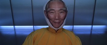 Movie still from “Zoolander” (2001), directed by Ben Stiller – An older man wearing a yellow shirt and a white mask; Close Up shot, Low angle