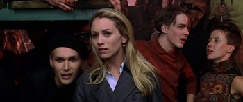 Movie still from “Zoolander” (2001), directed by Ben Stiller – A woman with long blonde hair wearing a gray suit; Close Up shot, Over the shoulder angle