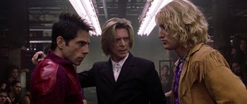 Movie still from “Zoolander” (2001), directed by Ben Stiller – A group of people standing next to each other in a room; Medium shot, Over the shoulder angle