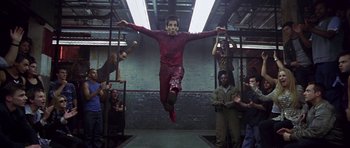 Movie still from “Zoolander” (2001), directed by Ben Stiller – A man jumping in the air in front of a group of people; Wide shot, Low angle