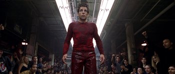 Movie still from “Zoolander” (2001), directed by Ben Stiller – A man in red shirt and red pants standing in front of a crowd of onlookers; Medium shot, Low angle