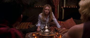 Movie still from “Zoolander” (2001), directed by Ben Stiller – A woman sitting on the ground with a tea pot; Medium shot, Over the shoulder angle