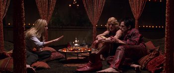 Movie still from “Zoolander” (2001), directed by Ben Stiller – A group of people sitting around a fire pit; Wide shot, High angle