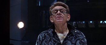 Movie still from “Zoolander” (2001), directed by Ben Stiller – An older man wearing glasses and a black shirt; Close Up shot, Low angle