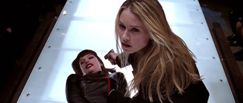 Movie still from “Zoolander” (2001), directed by Ben Stiller – A woman holding a knife in front of a doll; Close Up shot, Over the shoulder angle