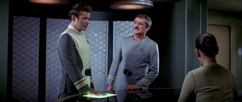Movie still from “Star Trek: The Motion Picture” (1979), directed by Robert Wise – Two men in star trek uniforms standing next to each other on a table; Medium shot, Over the shoulder angle