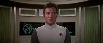 Movie still from “Star Trek: The Motion Picture” (1979), directed by Robert Wise – A man wearing a star trek uniform in front of a window; Close Up shot, Low angle