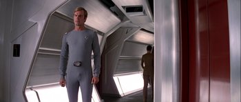 Movie still from “Star Trek: The Motion Picture” (1979), directed by Robert Wise – A man in a gray suit standing next to another man in a brown suit; Medium shot, Low angle