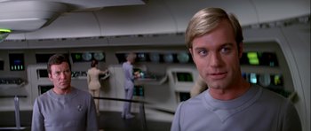 Movie still from “Star Trek: The Motion Picture” (1979), directed by Robert Wise – A man standing in front of a group of people in a room; Close Up shot, Over the shoulder angle