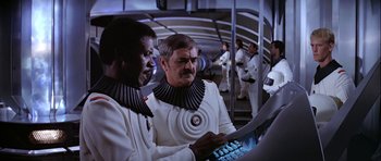 Movie still from “Star Trek: The Motion Picture” (1979), directed by Robert Wise – Two men in white suits looking at a computer screen; Medium shot, High angle