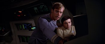 Movie still from “Star Trek: The Motion Picture” (1979), directed by Robert Wise – Two men are sitting next to each other in a room; Medium shot, Low angle