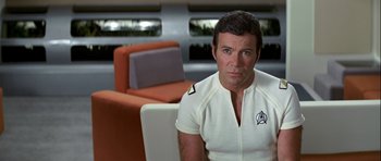 Movie still from “Star Trek: The Motion Picture” (1979), directed by Robert Wise – A man sitting in a chair wearing a white shirt; Medium shot, Over the shoulder angle