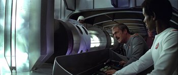 Movie still from “Star Trek: The Motion Picture” (1979), directed by Robert Wise – A man in a suit and tie next to a machine; Medium shot, Low angle