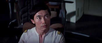 Movie still from “Star Trek: The Motion Picture” (1979), directed by Robert Wise – A man in a white shirt is looking at the camera; Close Up shot, Over the shoulder angle