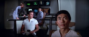 Movie still from “Star Trek: The Motion Picture” (1979), directed by Robert Wise – A group of men standing next to each other on top of a ship; Medium shot, Over the shoulder angle