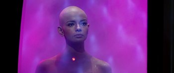Movie still from “Star Trek: The Motion Picture” (1979), directed by Robert Wise – A woman with a bald head is standing in front of a purple background; Close Up shot, Low angle