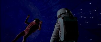 Movie still from “Star Trek: The Motion Picture” (1979), directed by Robert Wise – A person in a spacesuit looking up at an astronaut in a spacesuit; Wide shot, Overhead angle