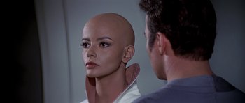 Movie still from “Star Trek: The Motion Picture” (1979), directed by Robert Wise – A man standing next to a woman with a bald head in front of a mirror; Close Up shot, Over the shoulder angle