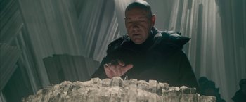 Movie still from “Superman Returns” (2006), directed by Bryan Singer – A man in a black shirt is looking down at a table; Close Up shot, Low angle